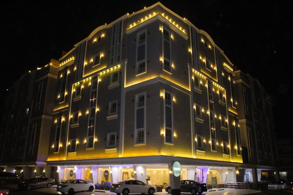 un grand bâtiment avec des lumières sur son côté dans l'établissement Staytion Express Orjwan Lebanon, à Djeddah