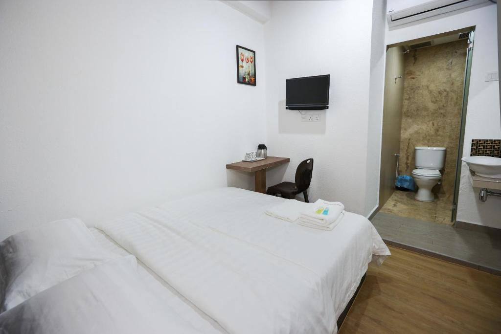 Postel nebo postele na pokoji v ubytování New Dawn Hotel Pontian Sdn Bhd