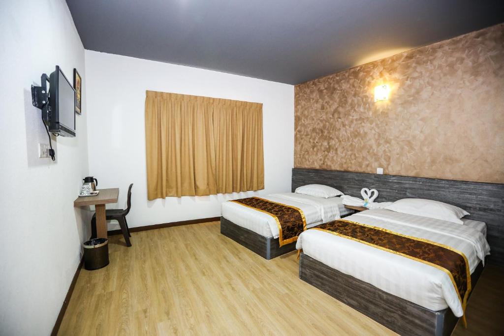 Postel nebo postele na pokoji v ubytování New Dawn Hotel Pontian Sdn Bhd