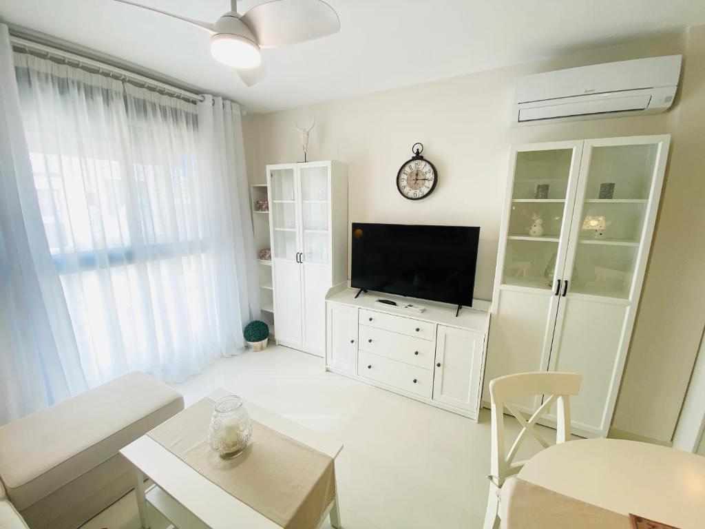 een woonkamer met een flatscreen-tv op een witte kast bij Town Apartment direkt im Zentrum von Denia in Denia