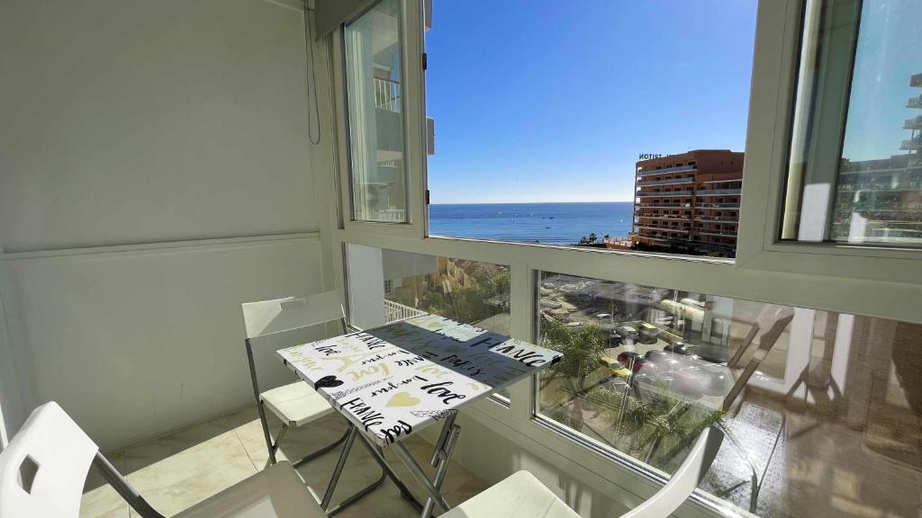 ベナルマデナにあるPool and Beach in Benalmádenaの海の景色を望む客室で、テーブルと椅子が備わります。