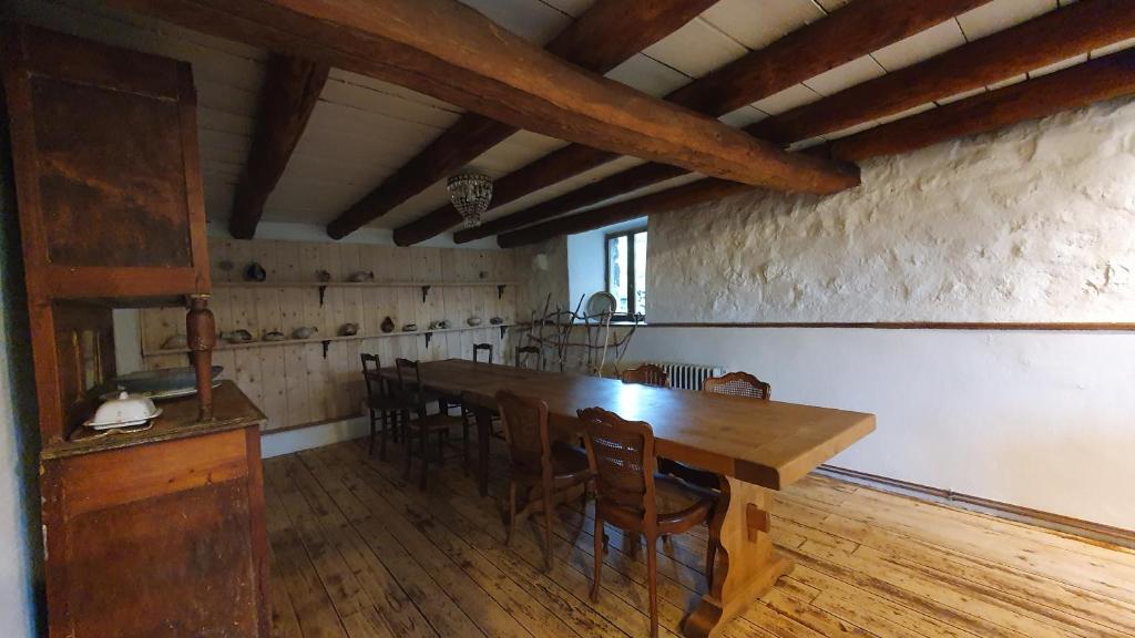 a dining room with a long wooden table and chairs at La chambre d&#39;hôte du Petit Mazilloux in Présailles