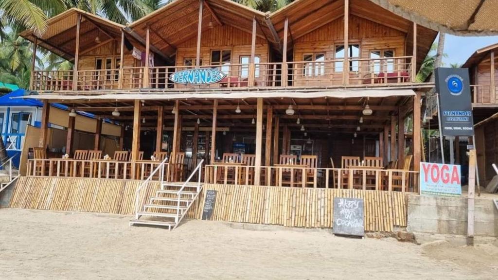 a large wooden building with stairs in front of it at Fernandes Bar and Restaurant in Canacona