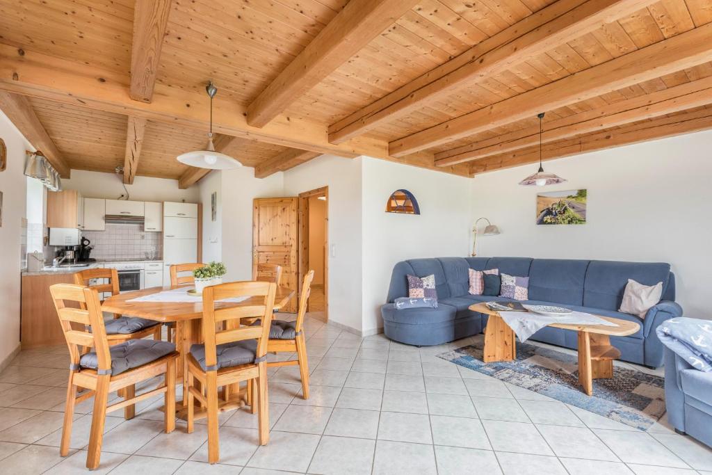 a living room with a table and a blue couch at Schäferhof Dircks Fewo 3 in Westerhever