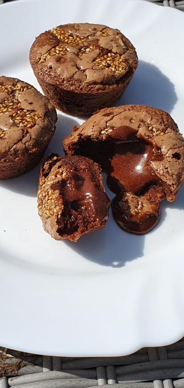 four chocolate donuts sitting on a white plate at La chambre d&#39;hôte du Petit Mazilloux in Présailles