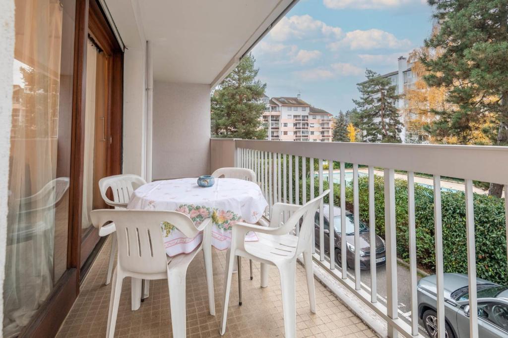 a table and chairs on a balcony with a view at Marmottes Furnished flat in Annecy