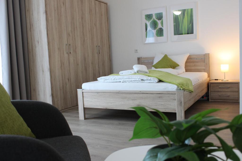 een slaapkamer met een bed met een groene deken erop bij greenpartment Boardinghousehotel Kelheim in Kelheim