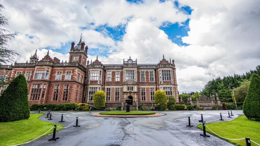 um grande edifício com um pátio em frente em Crewe Hall Hotel & Spa - Cheshire em Crewe