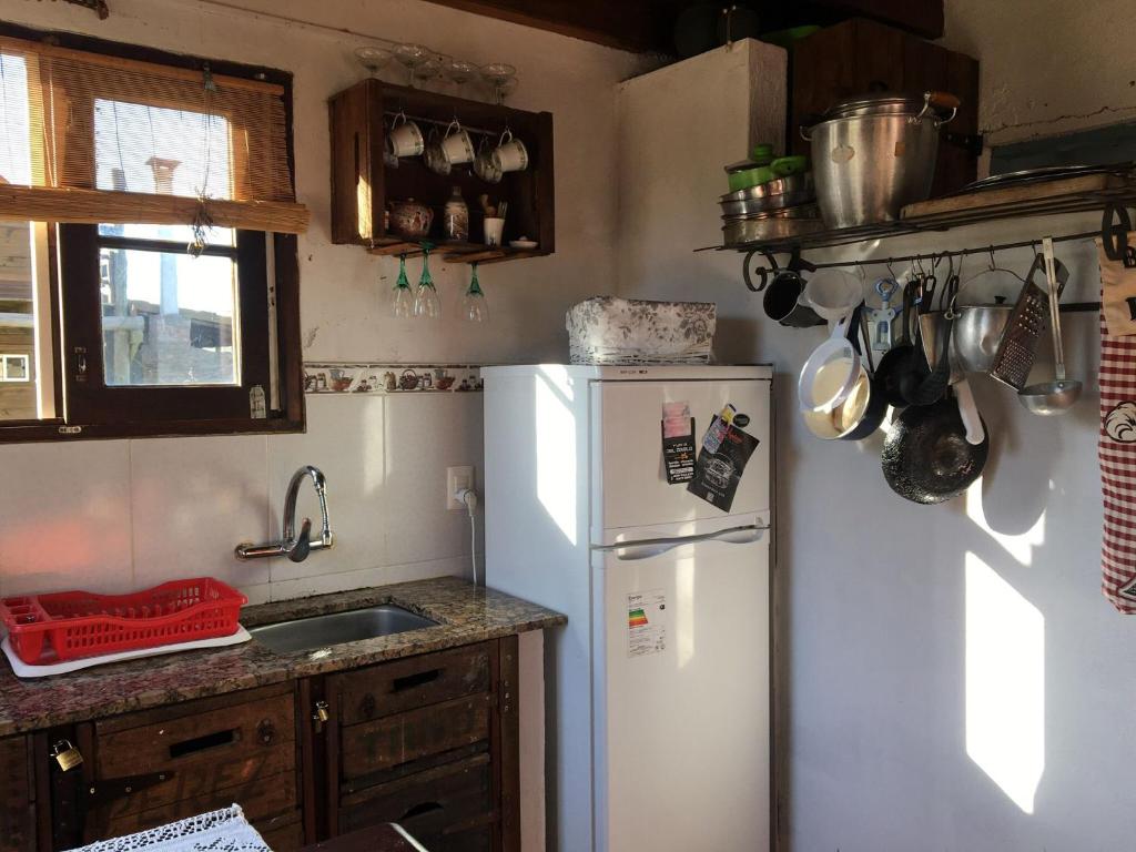 a kitchen with a white refrigerator and a sink at Abuelo Andrés in Punta Del Diablo