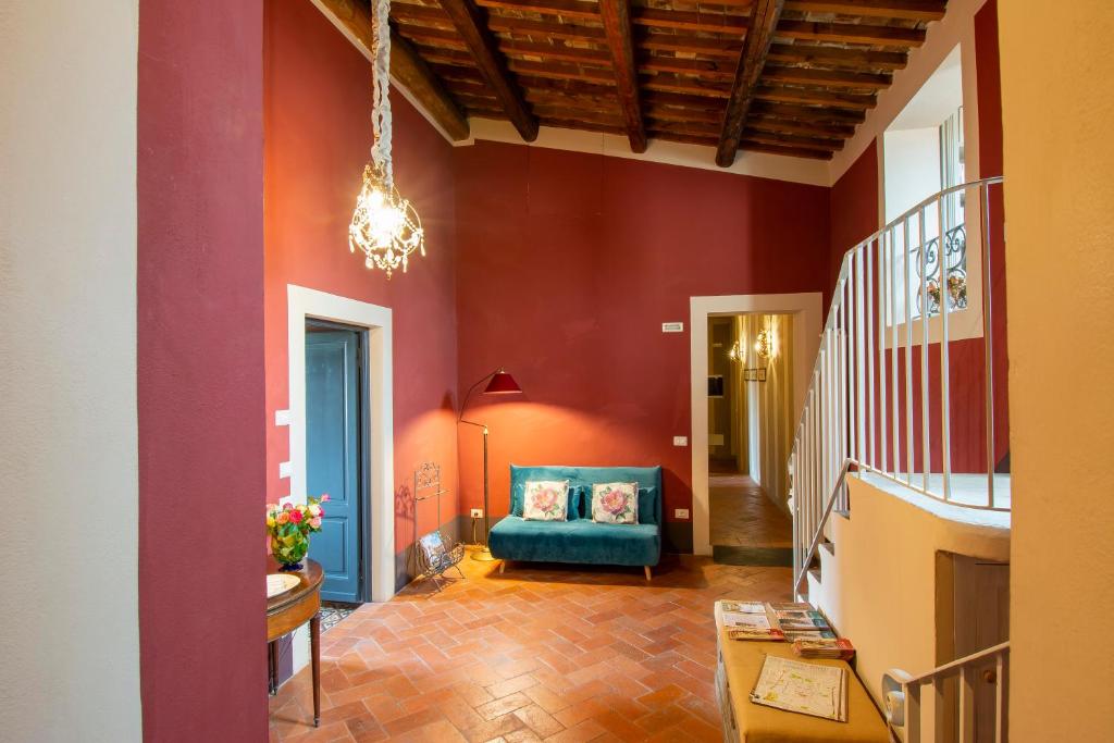 un soggiorno con pareti rosse e un divano blu di B&B Il Malconsiglio a Pistoia