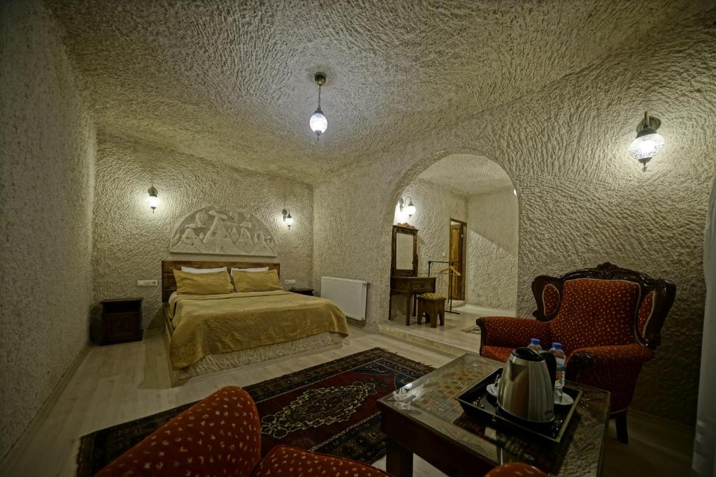 a bedroom with a bed and two chairs and a table at Gerdis Evi in Göreme