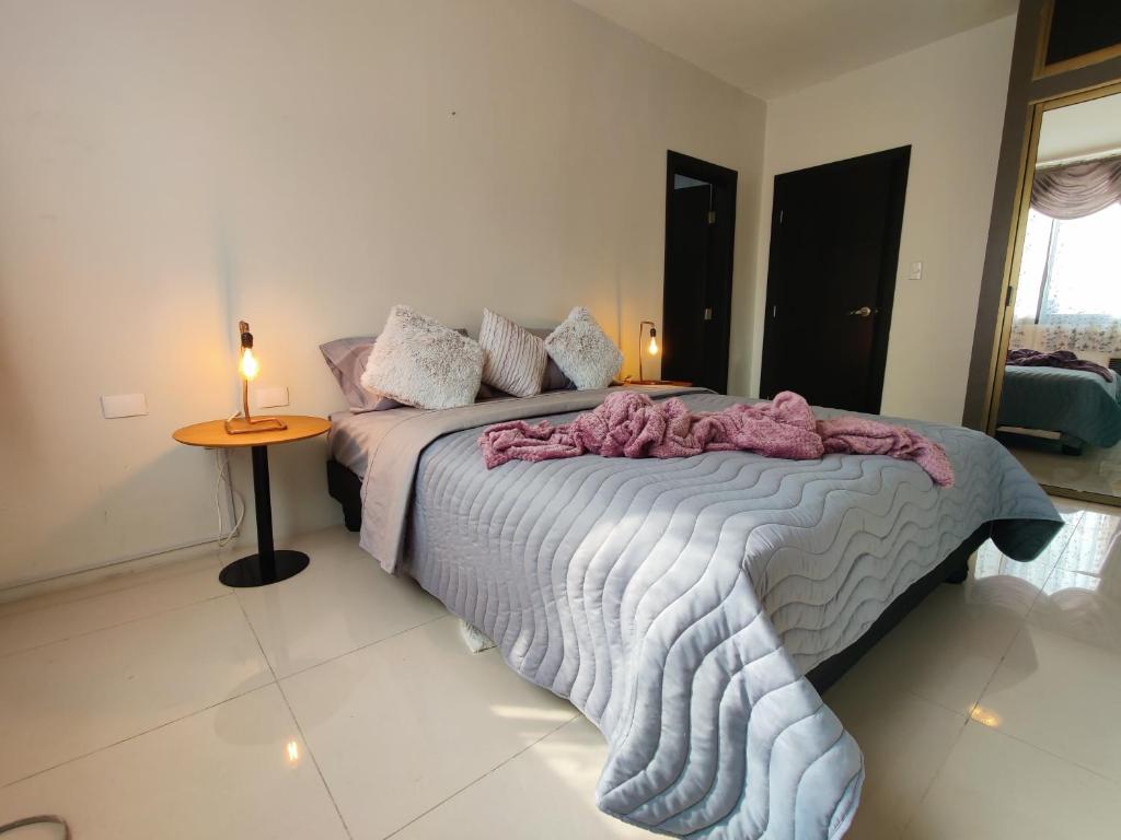 1 dormitorio con 1 cama y 1 mesa con lámpara en Lola's House Guayaquil Self Check-In & B&B, en Guayaquil