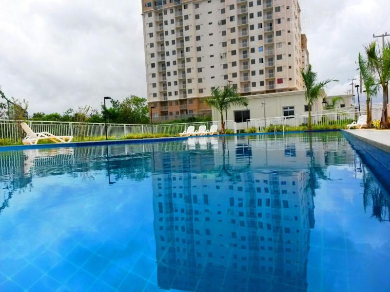uma grande piscina em frente a um edifício alto em APARTAMENTO ACONCHEGANTE PROXIMO A PRAIA DO ARACAGY em São Luís