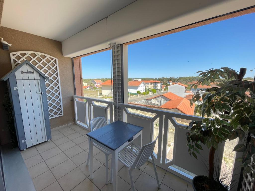 un balcon avec une table et des chaises et une vue dans l'établissement Le Surf, à Mimizan-Plage