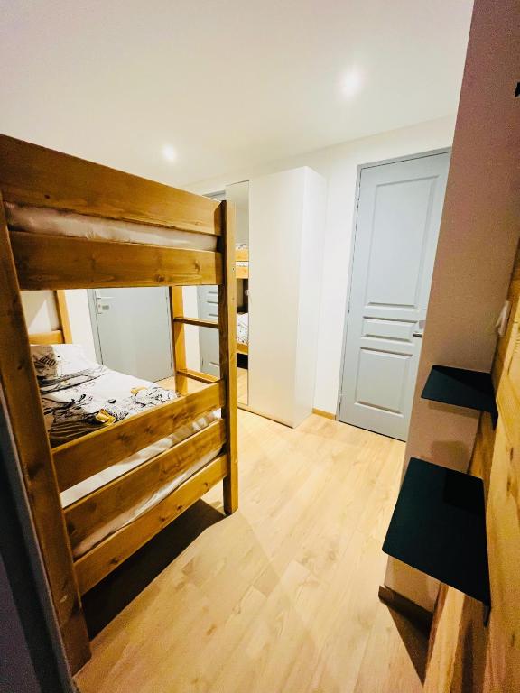 a room with two bunk beds and a door at Appart au centre de la station, entièrement rénové, , parking privé et wifi gratuit in Les Deux Alpes
