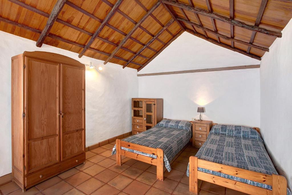um quarto com 2 camas e um tecto de madeira em Las Adelfas em Valverde