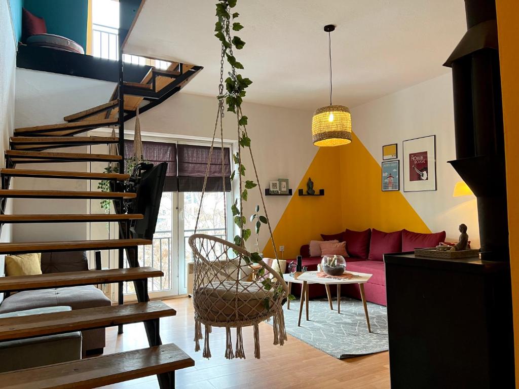 a living room with a spiral staircase and a couch at Light and Bright Central in Prishtinë