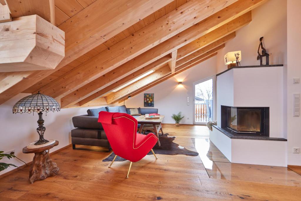 a living room with a fireplace and red chairs at Chalet Wild in Garmisch-Partenkirchen