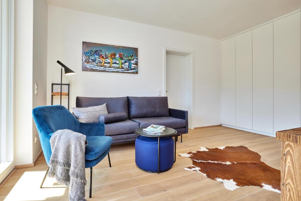 een woonkamer met een bank en een blauwe stoel bij Gams in Garmisch-Partenkirchen