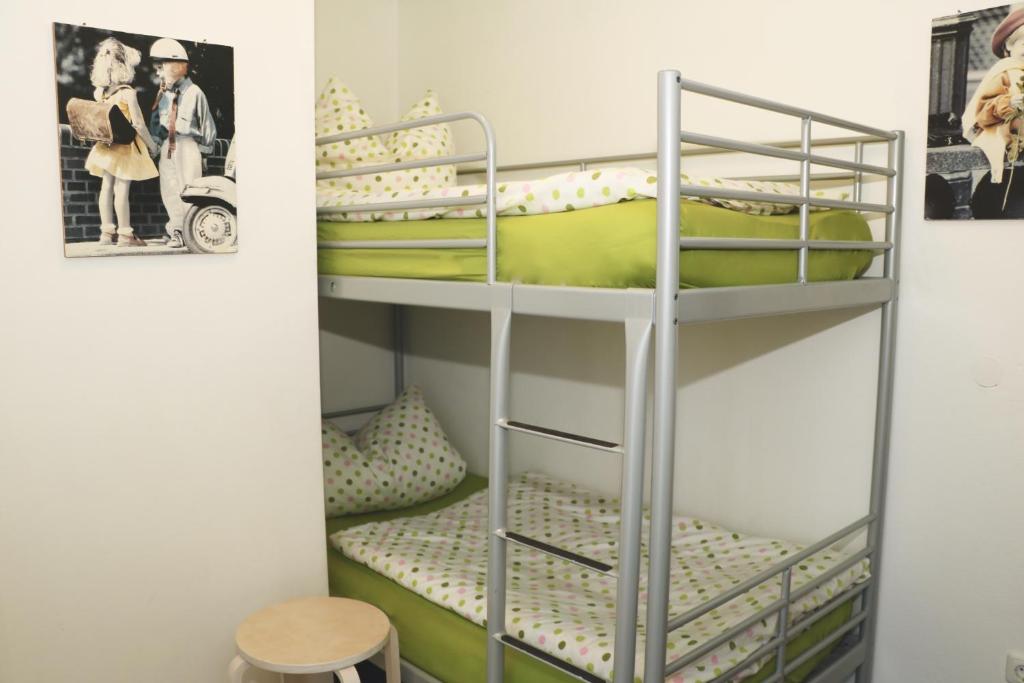 ガルミッシュ・パルテンキルヒェンにあるFerienwohnung Zugspitzeの緑色の二段ベッドとスツールが備わる二段ベッド付きの客室です。