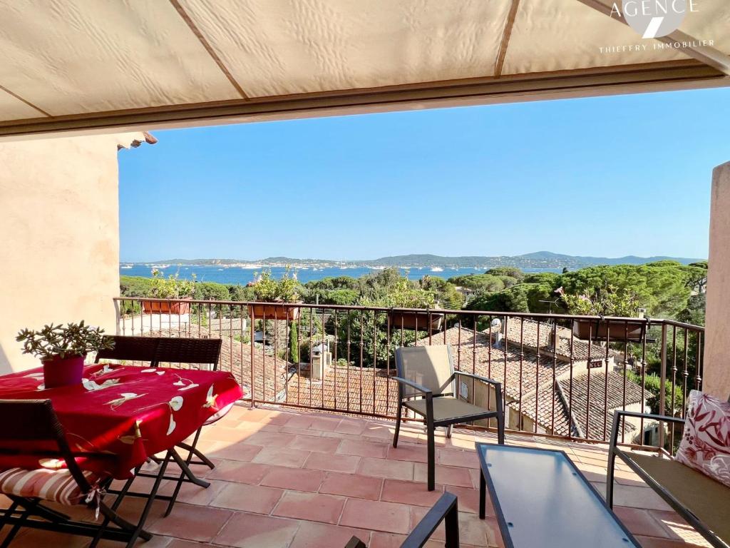 un patio avec une table et des chaises sur un balcon dans l'établissement Le Tropezien, à Grimaud