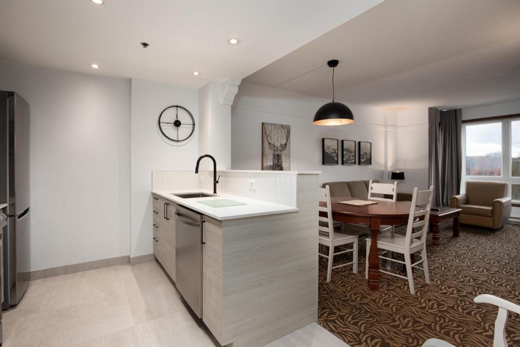 a kitchen and dining room with a table and chairs at Sommet Des Neiges in Mont-Tremblant