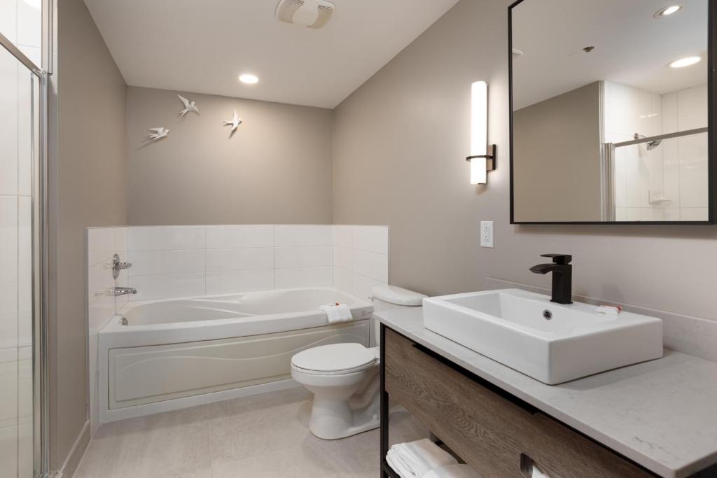 a bathroom with a sink and a toilet and a tub at Sommet Des Neiges in Mont-Tremblant