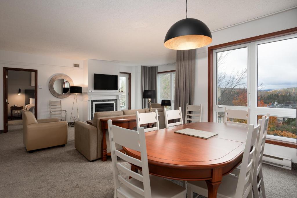a dining room and living room with a table and chairs at Sommet Des Neiges in Mont-Tremblant