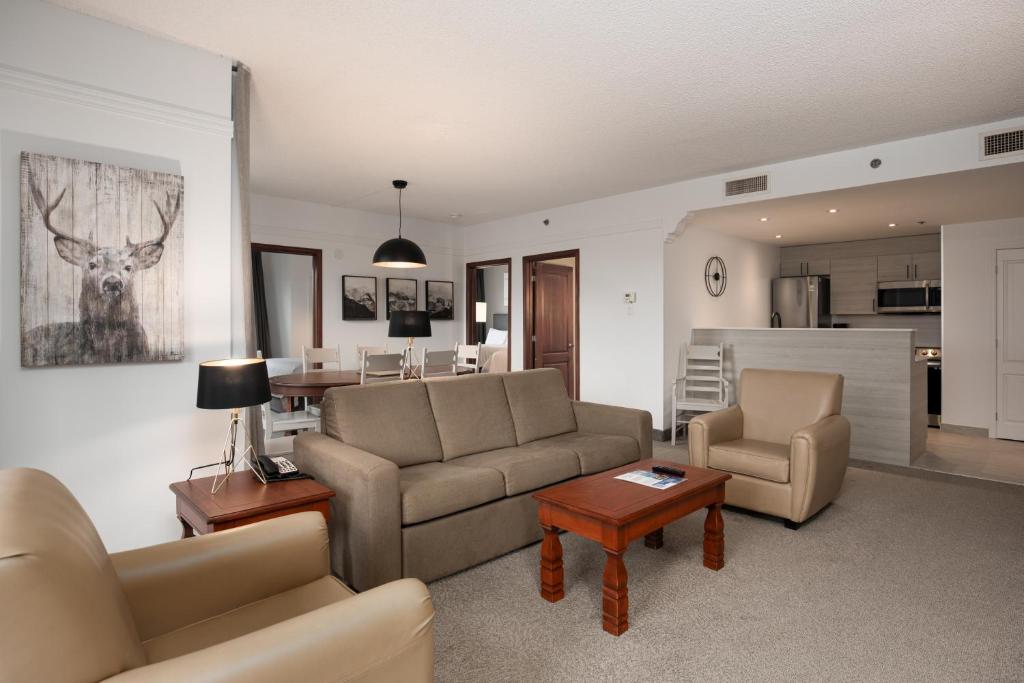 a living room with a couch and chairs and a table at Sommet Des Neiges in Mont-Tremblant