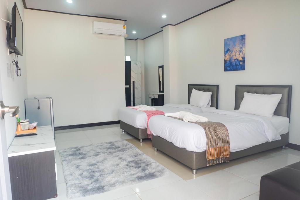 - une chambre avec 2 lits et un miroir dans l'établissement DD Grand Hotel, à Ban Na Ta Kai