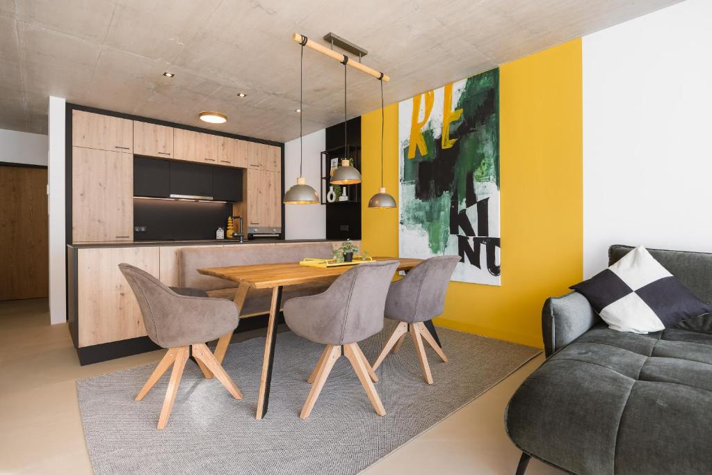 cocina y sala de estar con mesa de madera y sillas en Apart Momente, en Grins