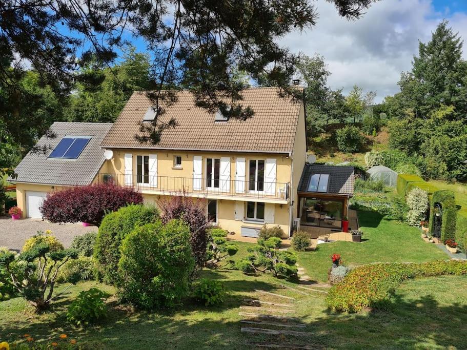 ein großes gelbes Haus mit Garten in der Unterkunft Agréable Gîte au sein d'une propriété arborée in Murol