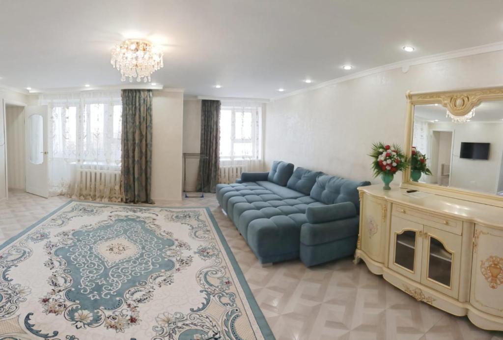 salon z niebieską kanapą i lustrem w obiekcie 2-х комнатная квартира посуточно w mieście Kokczetaw