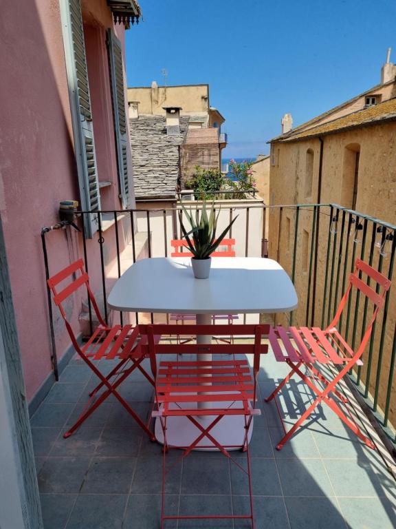 een witte tafel en 2 stoelen op een balkon bij Angelina in Bastia