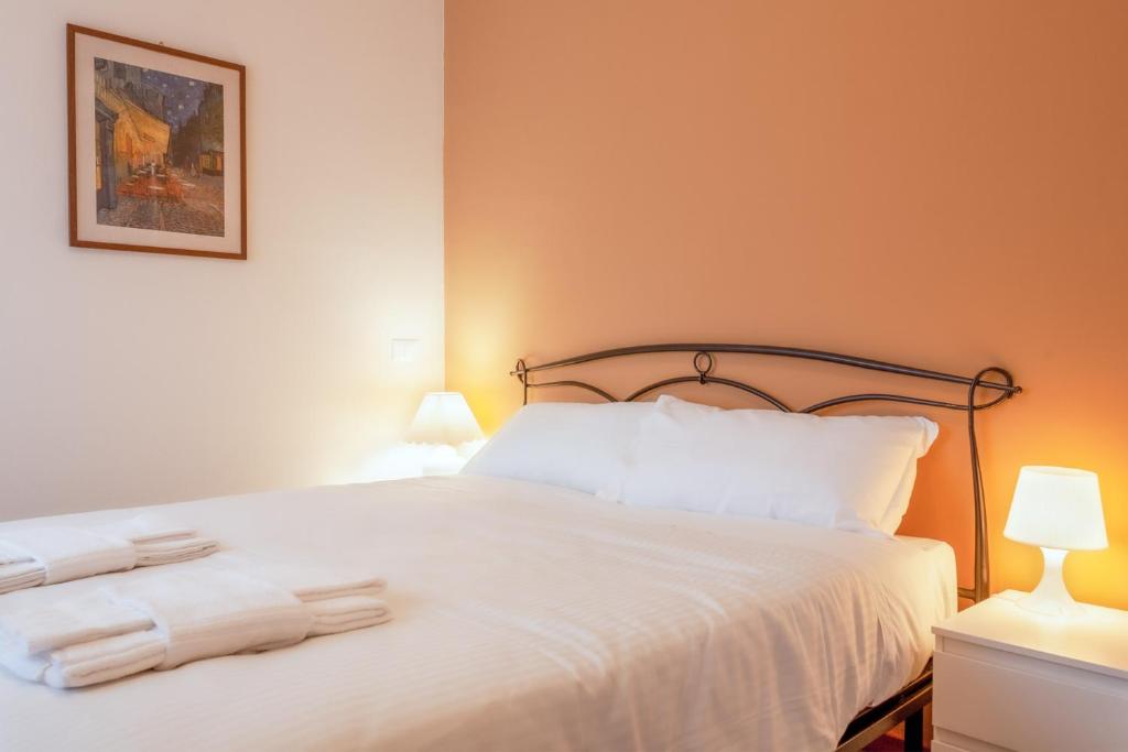 1 dormitorio con 1 cama blanca y 2 toallas en BnButler - Isonzo - Luminoso Appartamento in Porta Romana en Milán
