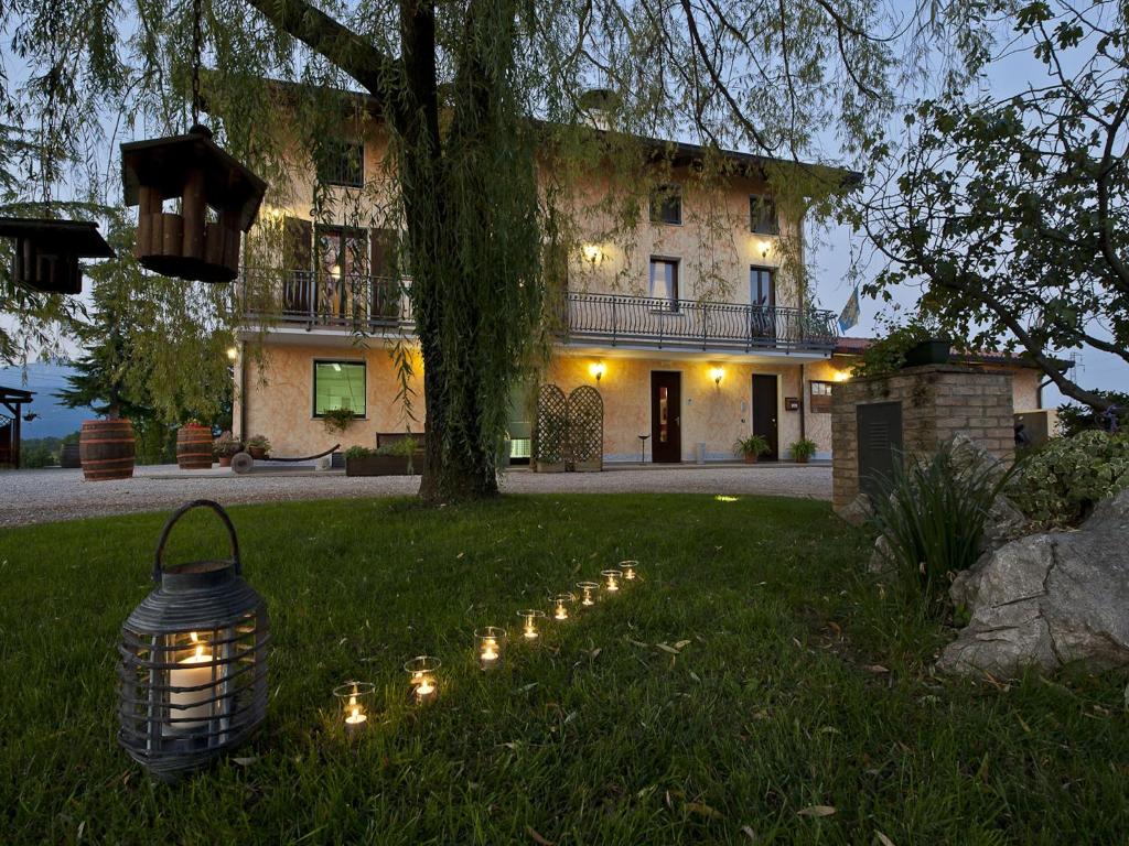 a house with a string of lights in the grass at Agriturismo Contessi in San Daniele del Friuli