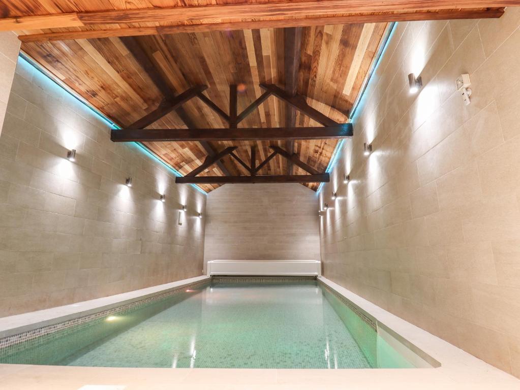 an indoor swimming pool with a wooden ceiling at South Hillswood Farm in Leek