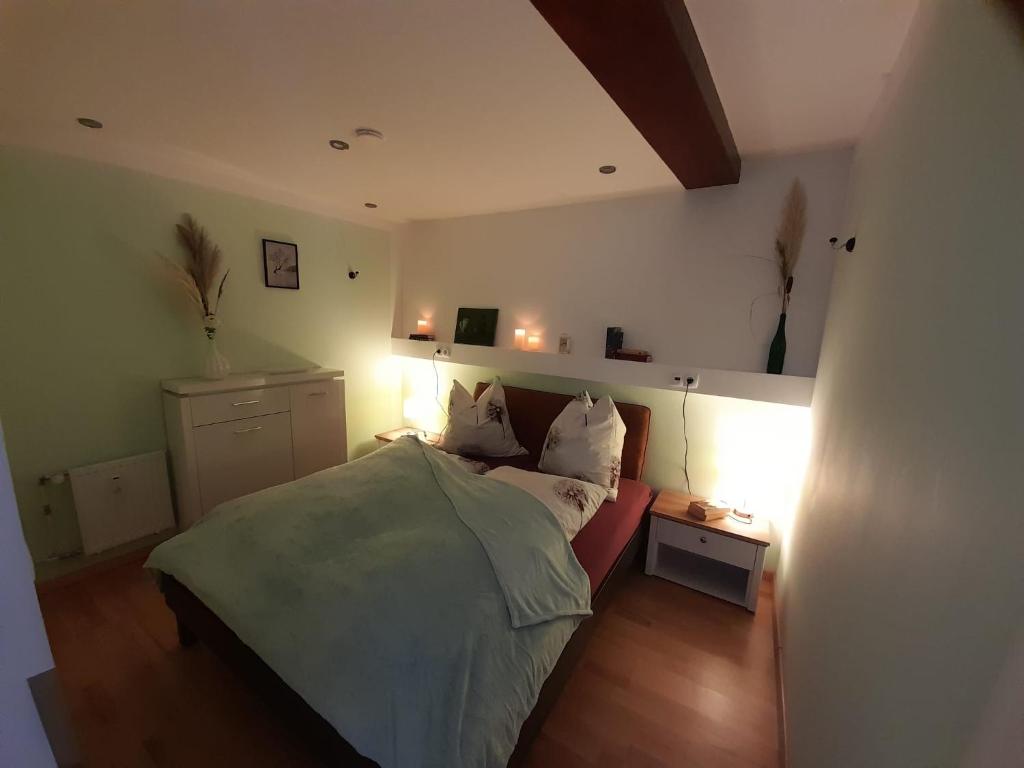 Schlafzimmer mit einem Bett und einem Tisch mit Lampen in der Unterkunft Neuendorf 30 in Quedlinburg