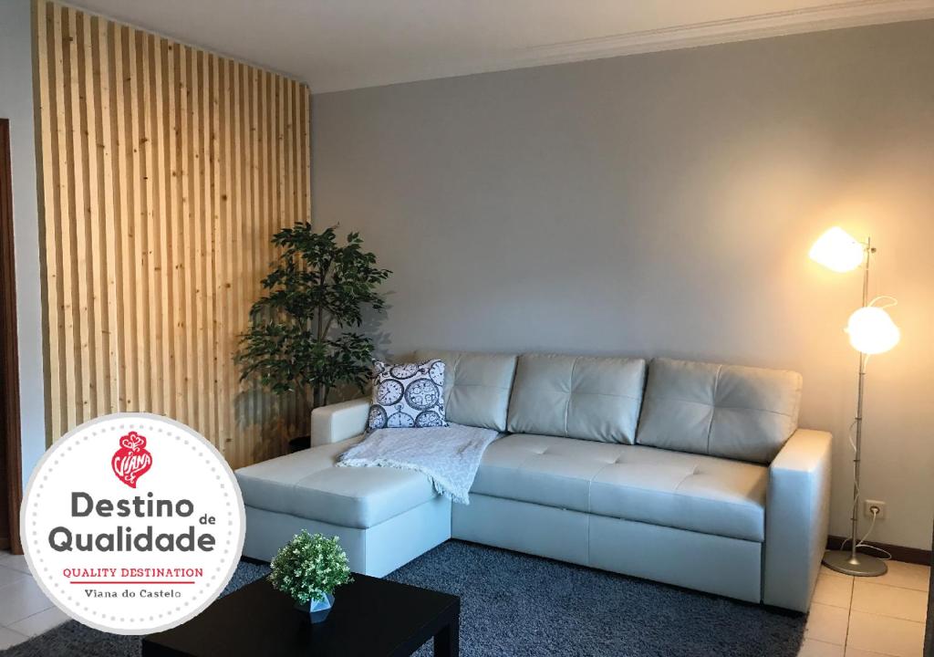 ein Wohnzimmer mit einem Sofa und einem Tisch in der Unterkunft Casa de Lencastre in Viana do Castelo