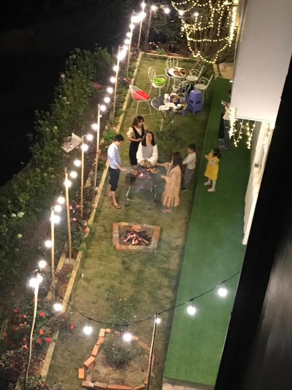 a group of people sitting in a garden at night at Villa Trung Nghĩa 16 in Da Lat