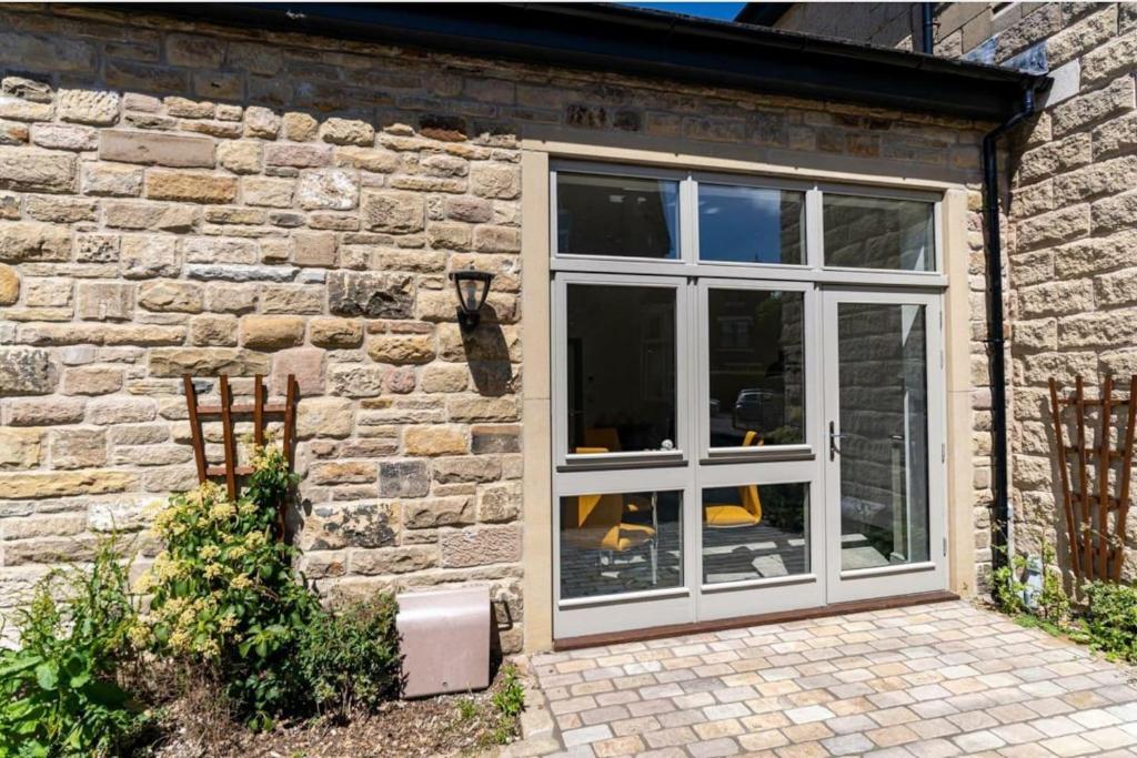 a stone building with a sliding glass door at Impeccable 1-Bed Apartment in Buxton Town Center in Buxton
