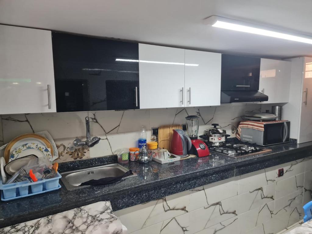 - un comptoir de cuisine avec évier et four micro-ondes dans l'établissement بالوما, à Temara
