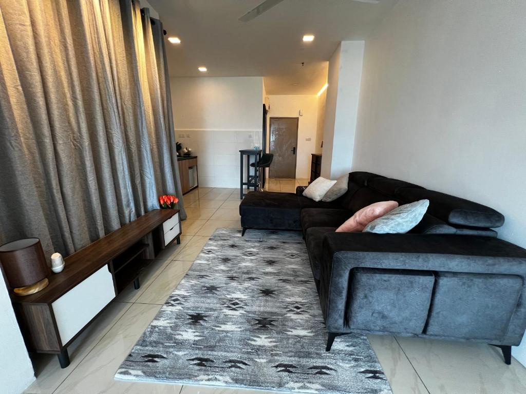 uma sala de estar com um sofá preto e um tapete em ITCC Manhattan Suites by PRIME em Penampang