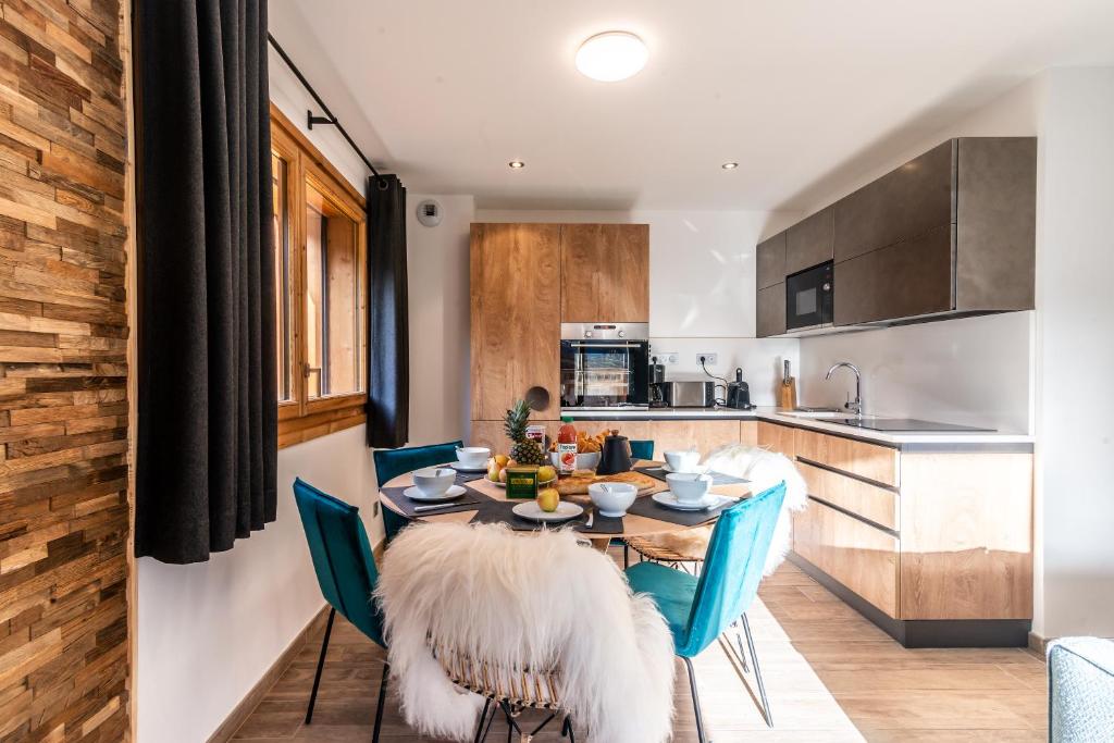 une cuisine et une salle à manger avec une table et des chaises dans l'établissement MAS JOUX PLANE 102, à Morzine