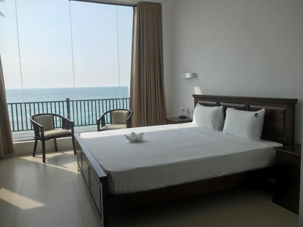 een slaapkamer met een bed en uitzicht op de oceaan bij White Sand Villa - Beach front in Hikkaduwa