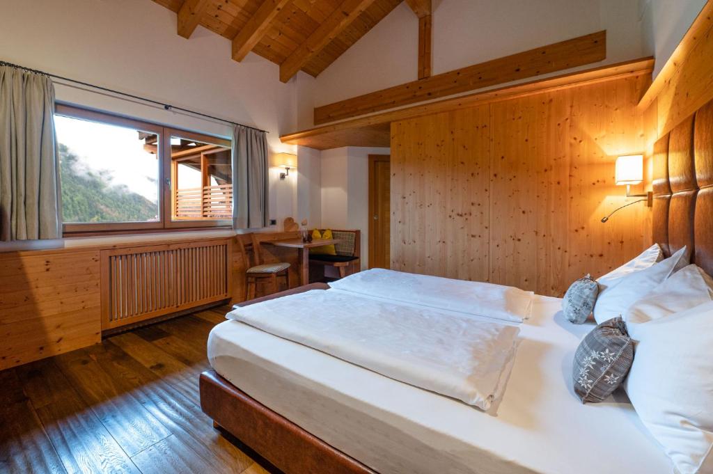 sypialnia z dużym łóżkiem i dużym oknem w obiekcie Residence Sovara w mieście Santa Cristina Valgardena