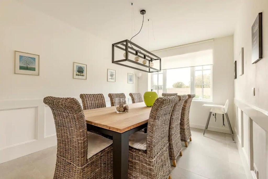 a dining room with a wooden table and chairs at Maison Mathieu in Bilzen