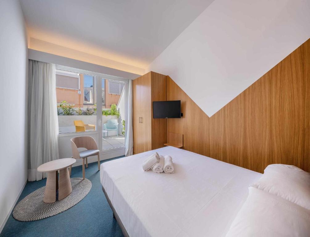 a bedroom with a large white bed and a window at Nature by Raidom in Alicante