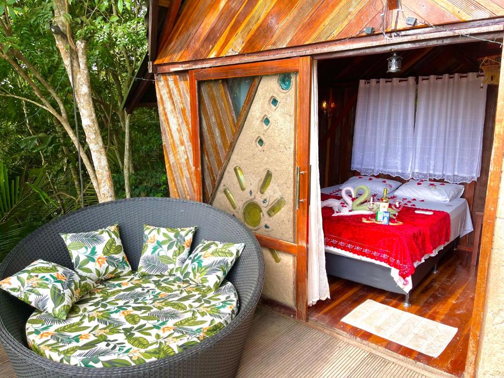 uma pequena casa com uma cadeira e uma cama em TerrAmor Amazon em Alter do Chão