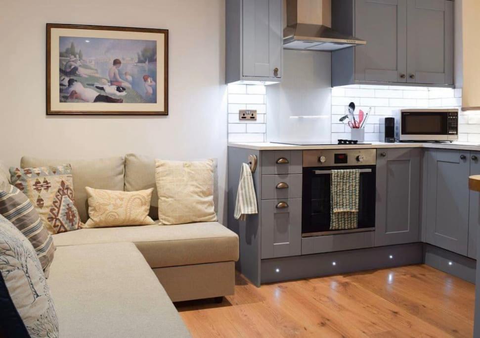 sala de estar con sofá y cocina en The Snug Entire home Sleeps 2, Stratford upon Avon, en Shottery